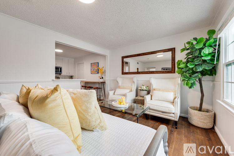 A bedroom with a bed, chair, and mirror.