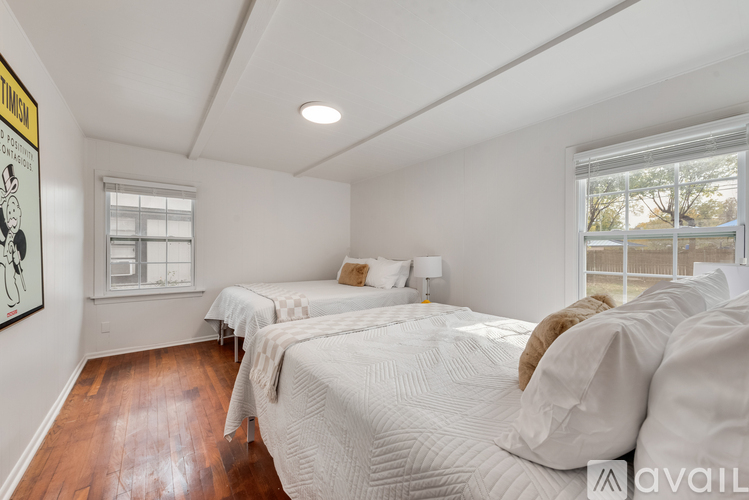 A bedroom with two beds and a window.