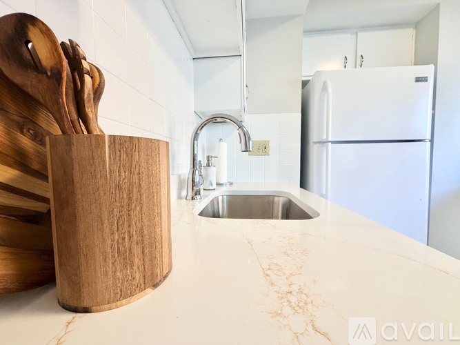 A kitchen with a marble countertop and a wooden knife block.