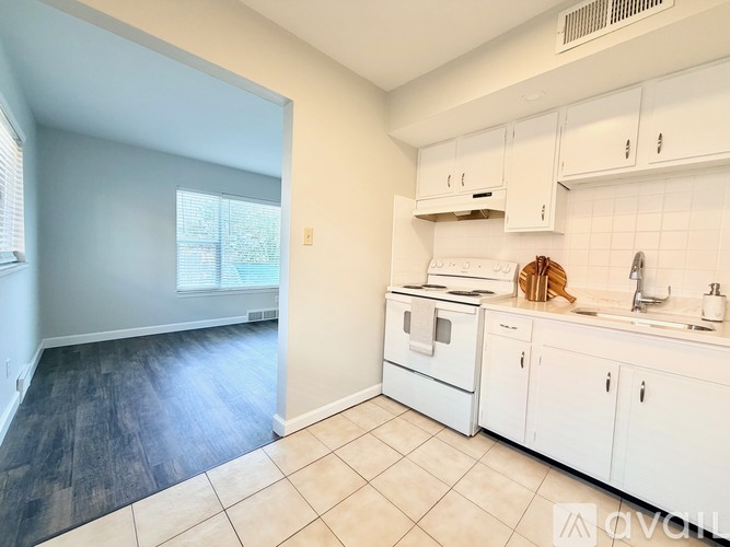 A kitchen with white cabinets and a white fridge.