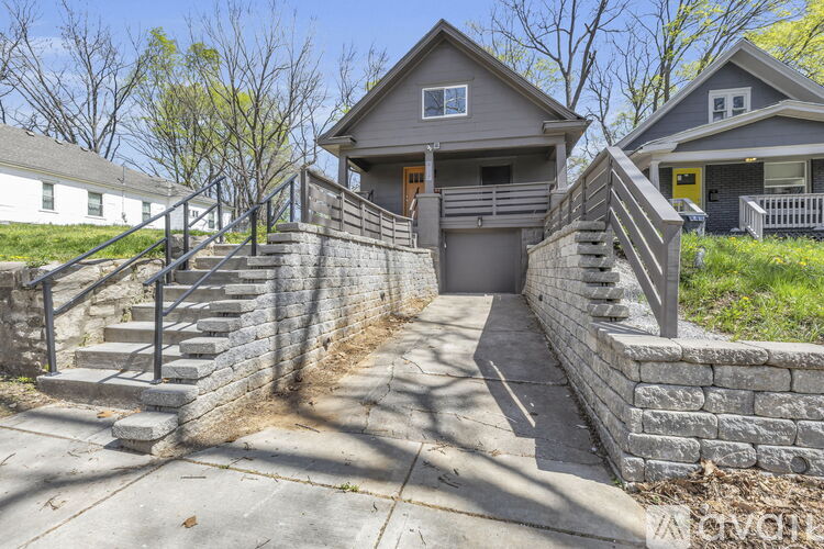 A house with a grey roof and a stone wall.