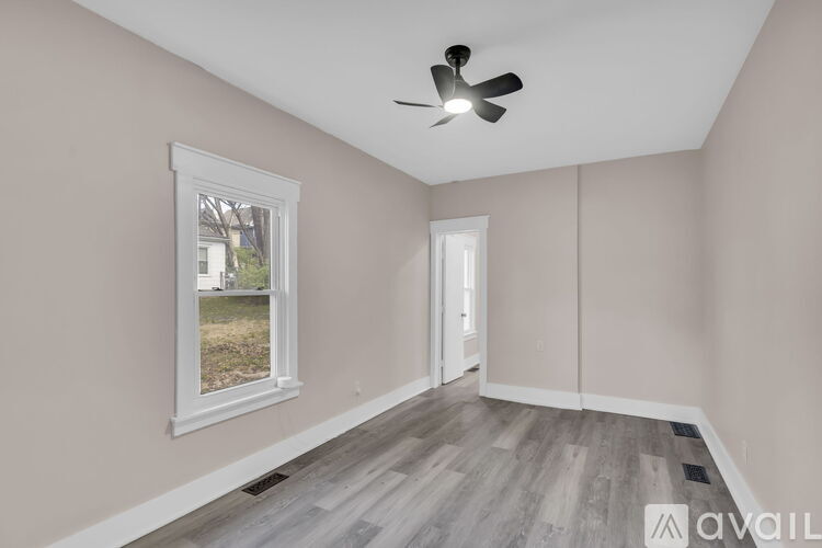 A room with a ceiling fan and a window.