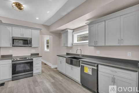 A kitchen with white cabinets and a black stove top oven.