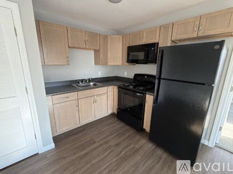 A kitchen with wooden cabinets and black appliances.