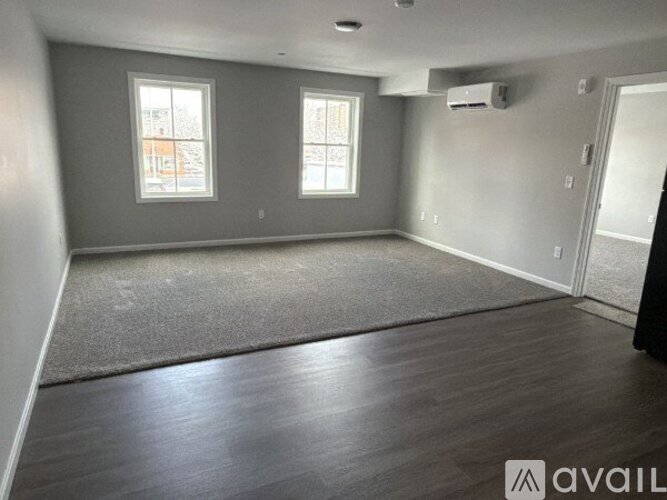 A spacious room with grey walls and a wooden floor.