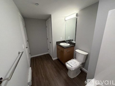 A small bathroom with a toilet, sink, and mirror.