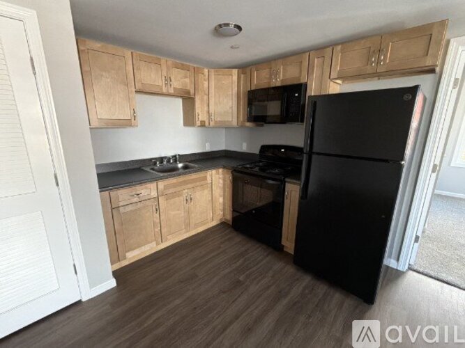 A kitchen with wooden cabinets and black appliances.