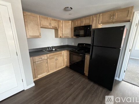 A kitchen with wooden cabinets and black appliances.