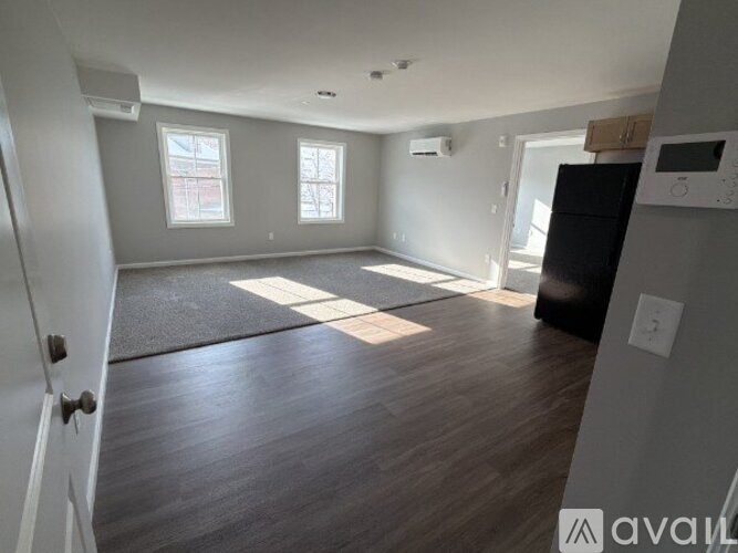 A spacious living room with hardwood floors and a large window.