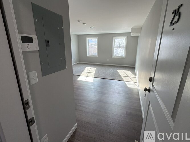 A spacious room with a door on the left and a window on the right.
