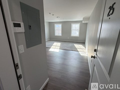 A spacious room with a door on the left and a window on the right.