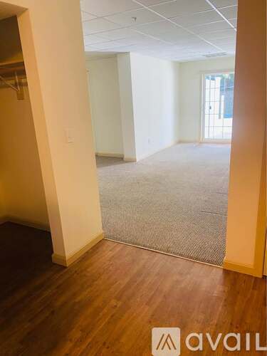 A room with wooden floors and white walls is available for rent.