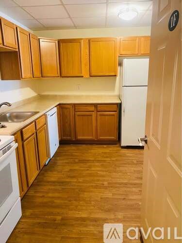 A kitchen with wooden cabinets and a white refrigerator.