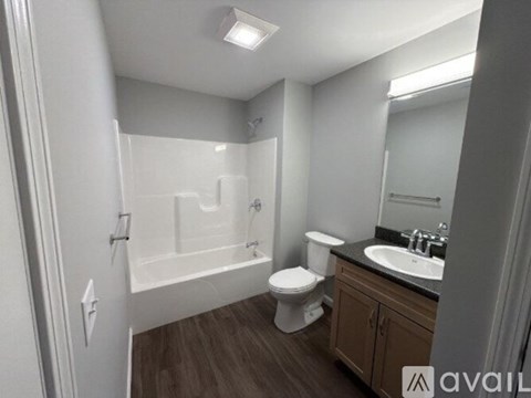 A bathroom with a white toilet, sink, and bathtub.