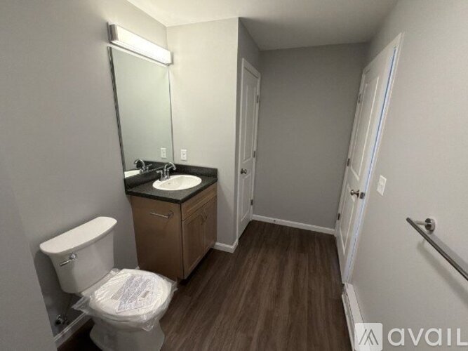 A bathroom with a toilet, sink, and mirror.