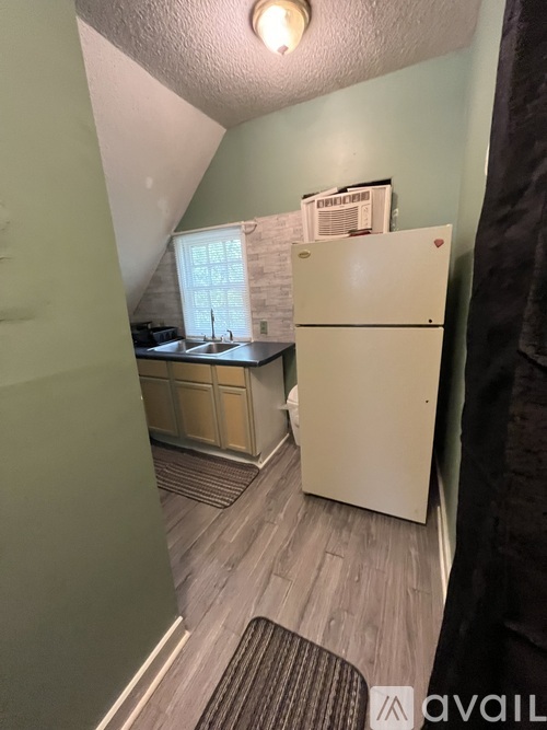 A kitchen with a white fridge and wooden cabinets.