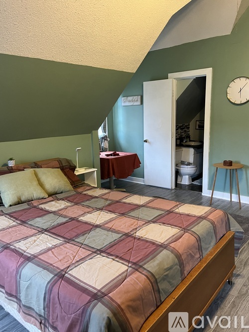 A bedroom with a bed and a clock on the wall.