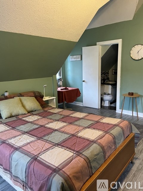 A bedroom with a bed and a clock on the wall.