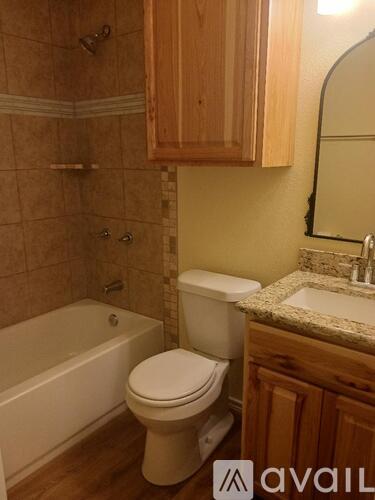 A white toilet sits next to a bathtub in a bathroom.