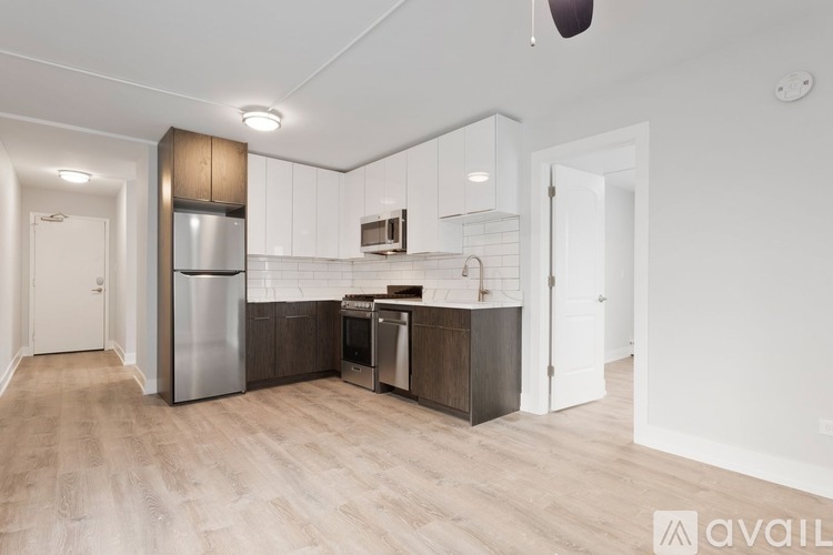 A modern kitchen with a stainless steel refrigerator and wooden cabinets.