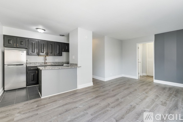 A kitchen with a refrigerator, cabinets, and a countertop.