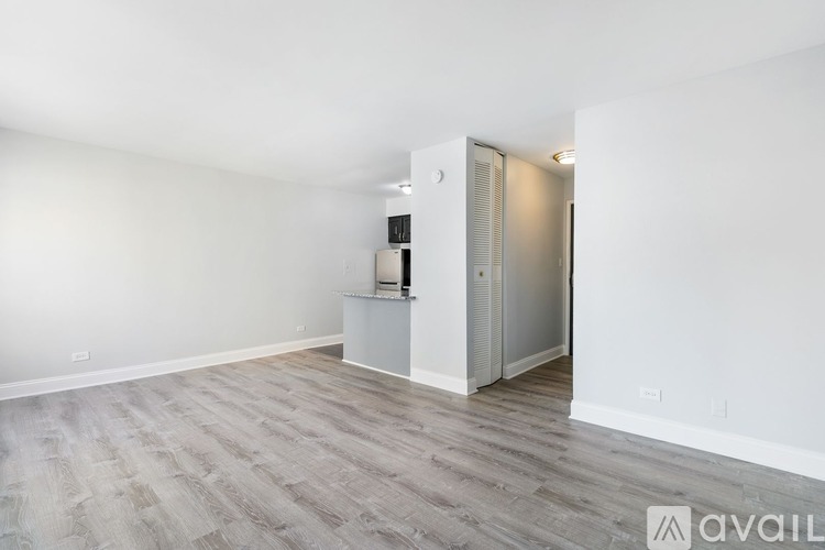 A room with a grey floor and a white wall with a door.