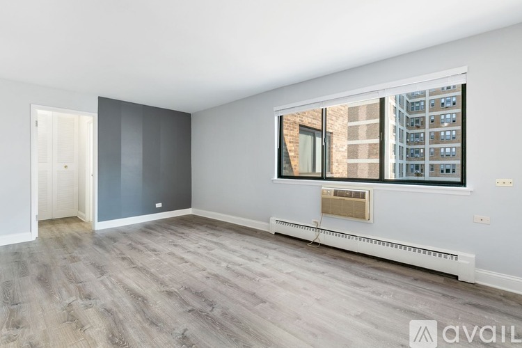 A spacious room with a large window and a view of a cityscape.