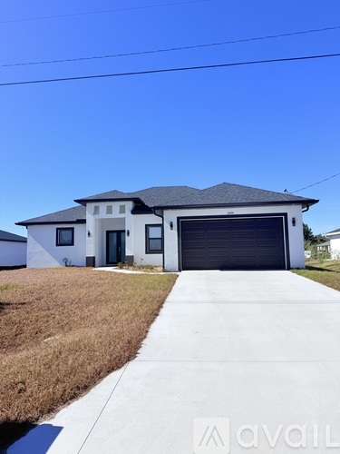 A two-story house with a garage door is for sale.