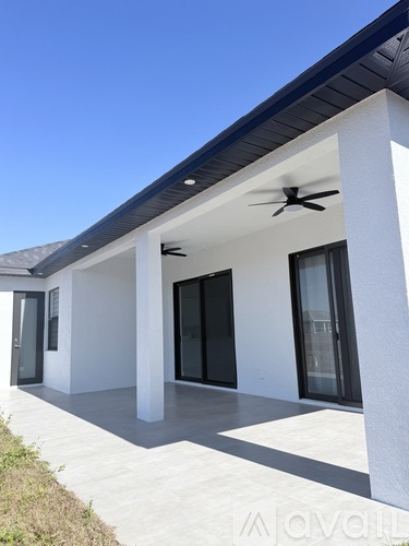 A modern house with a white exterior and a dark roof.