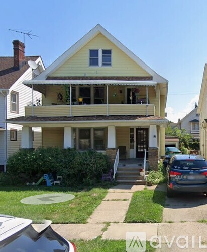 A yellow house with a car parked in front.