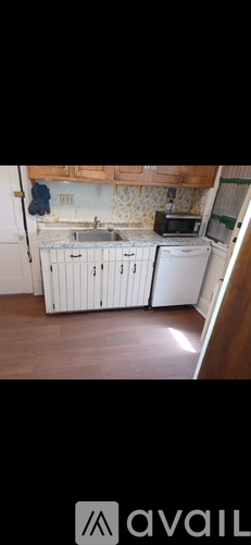 A kitchen with white cabinets and a tiled backsplash.