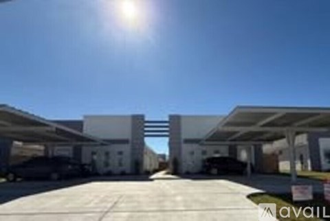 A sunny day at a parking lot with a car and a building in the background.