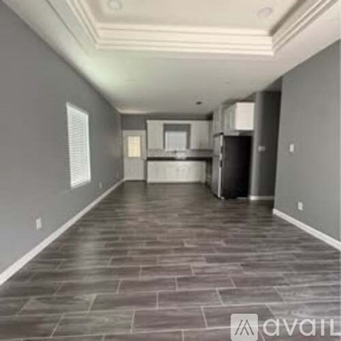 A spacious kitchen with grey walls and a stone floor.