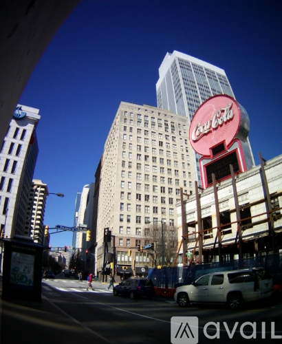 A Coca-Cola sign is on a building in a city.