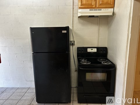 A black refrigerator and oven in a kitchen.
