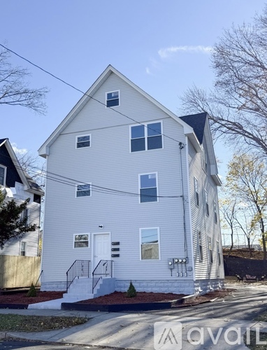 A two-story house with a white exterior and a black roof.