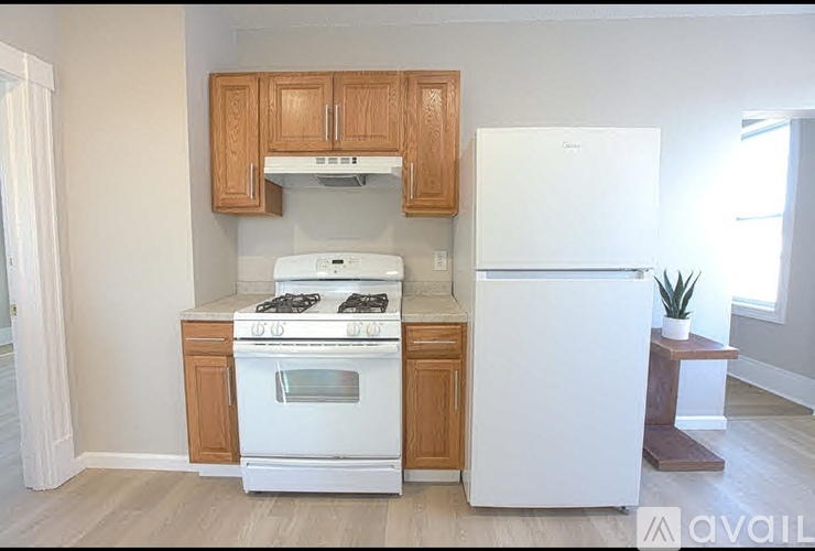 A white stove and refrigerator in a kitchen with wooden cabinets.