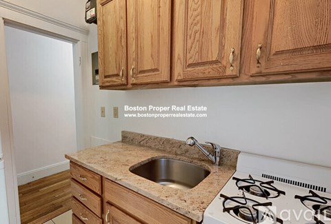 A kitchen with wooden cabinets and a granite countertop.