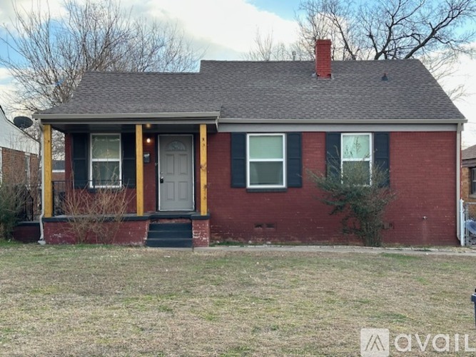 A red brick house with a white door and windows.