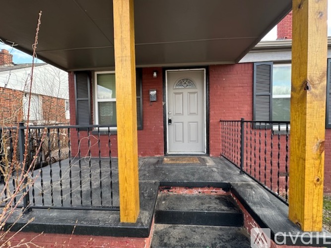 A white door is on the front of a red brick house.