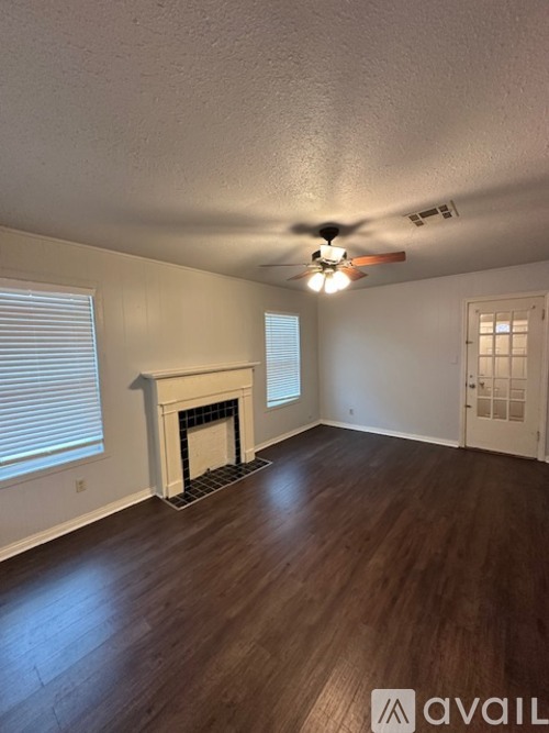 A room with a fireplace and a ceiling fan.