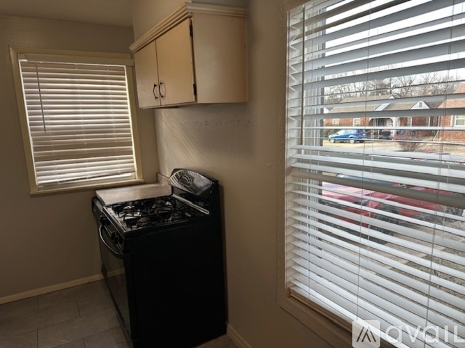 A kitchen area with a black stove and white cabinets.