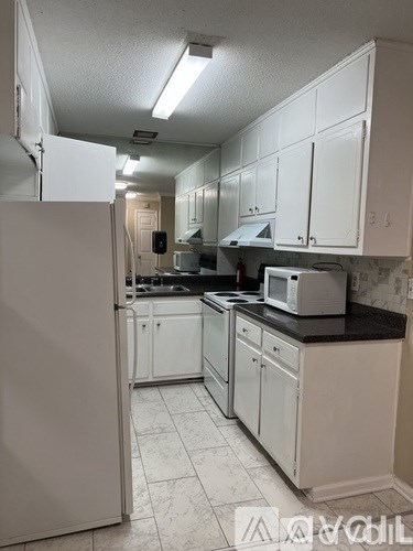 A kitchen with white cabinets and appliances.