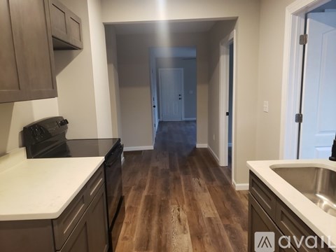 A kitchen with wooden floors and white countertops.