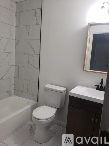 A bathroom with a toilet, sink, and tub.