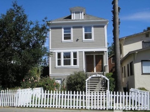 A house with a white picket fence in front.
