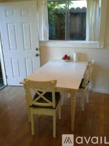 A white table and two chairs are in a room.