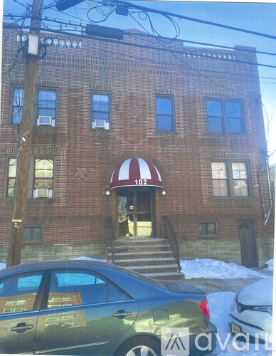 A red brick building with a white awning and the number 102 on it.