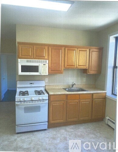 A kitchen with wooden cabinets and a white stove.