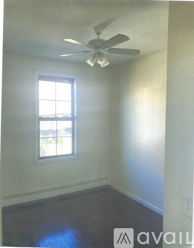 A room with a ceiling fan and a window.